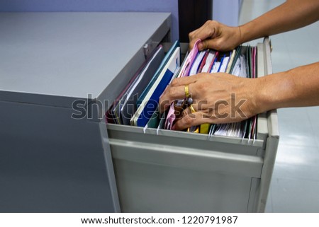 Hand of Man Search files document in a file cabinet in work office, concept business office life.