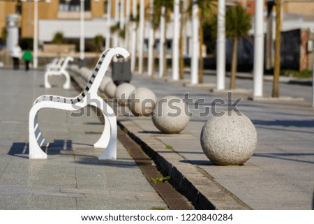 Photo of a metal bench with cold colours and sunlight