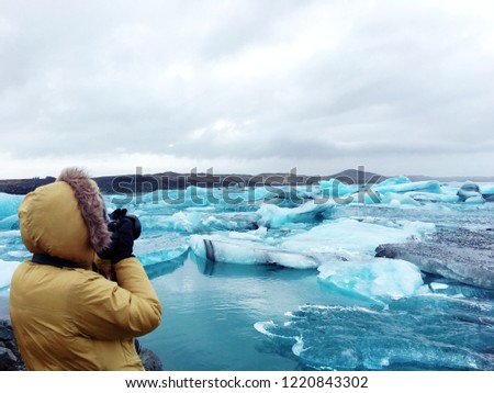 Tourist take picture of Ice floe in glacier lake, Iceland, Jokulsarlon lagoon.