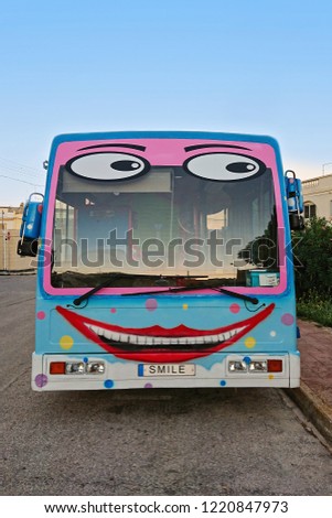 Cheerful school bus with painted funny face and smile
