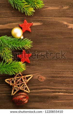 Christmas and New Year's Day decoration, balls, fir branches, red stars and wooden stars on wood background. Flat lay. View from above. Copy space for text.