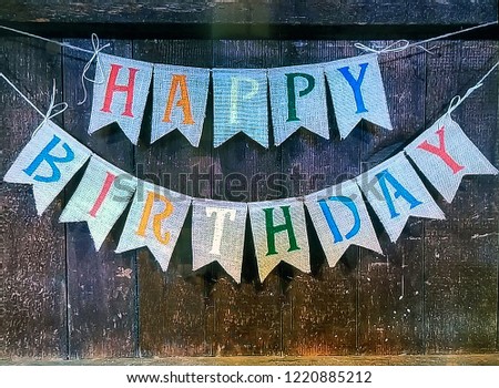 happy birthday banner sign hanging on rustic wood wall