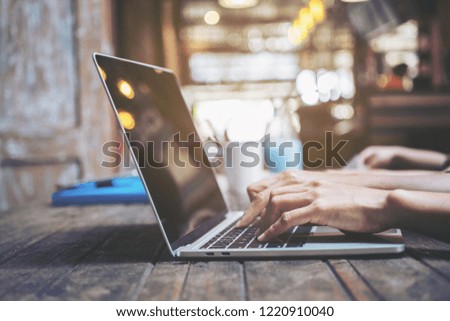 Hands of woman wearing  on the keyboard,businesswoman using laptop with coffee cup on wooden table in cafe selective focus