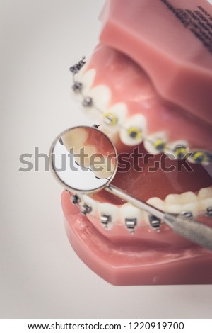 Detailed close up of dental instrument working on a denture or teeth on a table, dentistry