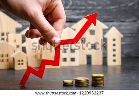 Wooden houses stand in a row from small to large with a red arrow up. concept of high demand for real estate. increase energy efficiency of housing. rise in house prices. property. population growth Royalty-Free Stock Photo #1220932237