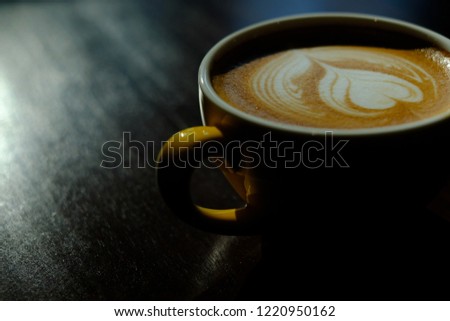 A Cup of hot latte art coffee on wooden table and window light in Morning, coffee with perfect leaf shape latte art, Lowkey light 