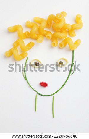 creative food concept, funny face made of ripe vegetables and raw Italian pasta as curly hair, top view, flat lay 