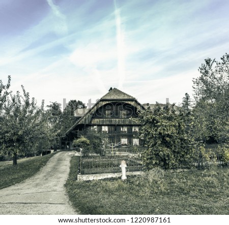 The old wooden house with a fence surrounding,picture vintage dark tone.