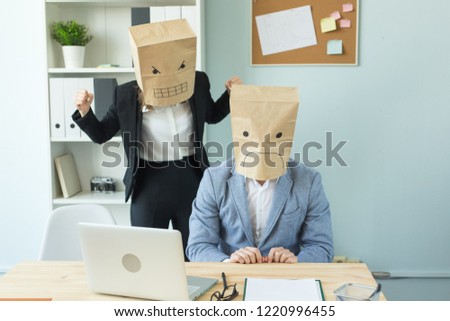 Business, emotions and people concept - woman and man wearing the packages on their heads with pictured emotions anger and fear