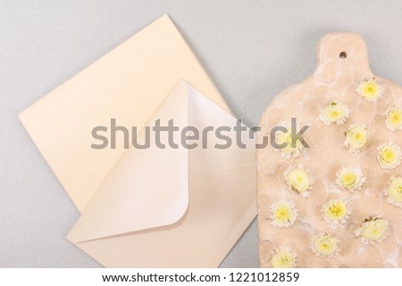Mockup envelope with flowers and a letter, greeting card for Valentines Day or wedding with place for your text. Flat lay, top view photo mock up. Board with  flowers on gray sparkled background.