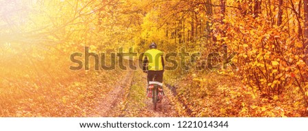 Beautiful autumn landscape, banner, panorama - cycling through dirt path in the autumn forest