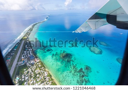 Tuvalu under the wing of the airplane. Aerial view of Funafuti atoll and airstrip of international airport in Vaiaku from air. Fongafale motu. Island nation in Polynesia, South Pacific Ocean, Oceania Royalty-Free Stock Photo #1221046468