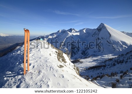 Wide angle view of a pair of back country ski on the top of the mountain in a clear bright day and scenic winter background