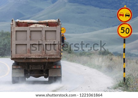 Truck on the road with information signs. Prohibition of overtaking and speeding