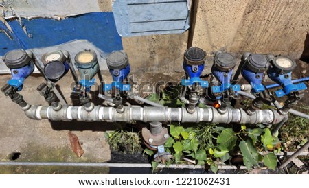 Set of eight water meters painted blue on the concrete outer wall of a closed shop and down on the sidewalk of even numbers of Mabini street facing Yap San Diego ancestral house. Cebu City-Philippines