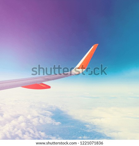 Aircraft wing against blue sky and clouds (aerial view, square)