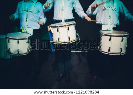 Drummer.The guy holding the drumsticks in his hand.Young man with drumsticks.A bearded man holding a stick in his hands.Marching drum.