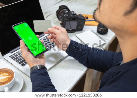 Newsletter concept Hand of businessman or designer checking message box on digital mobile phone on mock up green screen,Vintage tone filter.