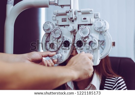 The ophthalmologist is measuring and finding customer’s diopter that it is long sighted or shortsighted. Pretty woman needs new pair of glasses. Beautiful woman is checking her eyes by used phoroptor. Royalty-Free Stock Photo #1221185173