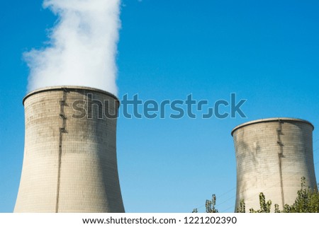 The cooling tower of a thermal power plant is braving white smoke