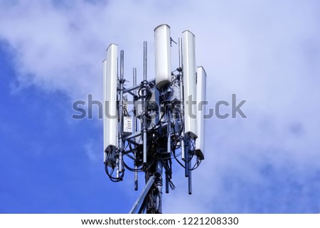 Telecommunication tower. Wireless Communication Antenna Transmitter. 3G, 4G and 5G Cell Site with white cloud and blue sky background. Royalty-Free Stock Photo #1221208330