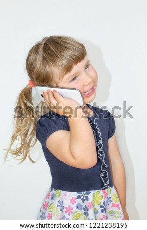 Little girl talking on a cell phone, on a white background.