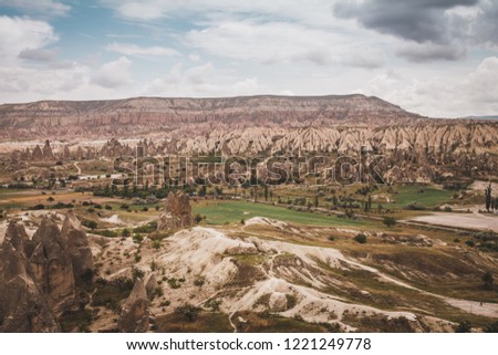 Epic landscape view over Cappadocia, located among the fairy chimney and volcanic rock formations clustered with spectacularly coloured valleys nearby.