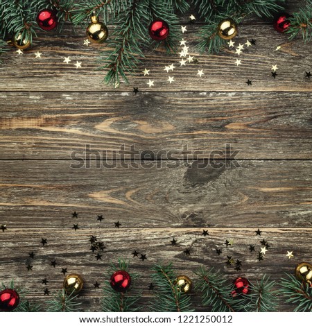 Old wooden Christmas background. Fir branches with baubles and gold stars. Space for text. Top view. Xmas square card. Royalty-Free Stock Photo #1221250012