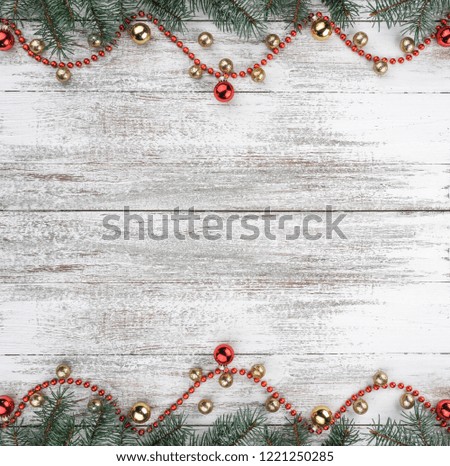 Old wooden Christmas background. Fir branches. Gold and red baubles. Red garlands. Top view. Space for your text. Xmas square card.