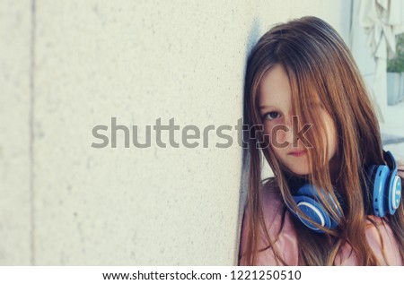 Portrait of cute teenage girl listening music on headphones