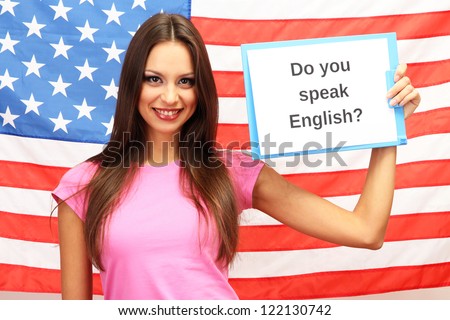 Young woman young woman holding tablet on background of American flag