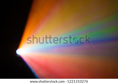 beautiful rainbow color wide lens projector with light beam for movie and cinema at night . smoke texture spotlight . effects screening for multimedia . black background . 