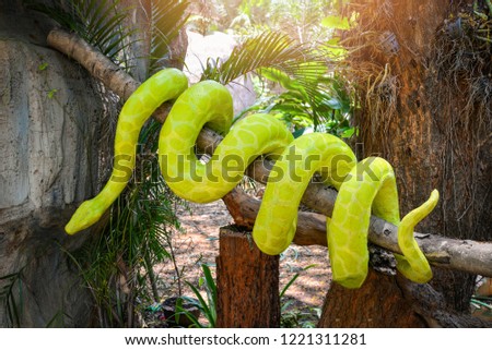 boa snake statue / the big green boa on tree branch on nature park Royalty-Free Stock Photo #1221311281