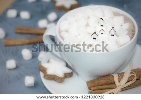 miniature penguins on a Cup of hot chocolate with marshmallows 