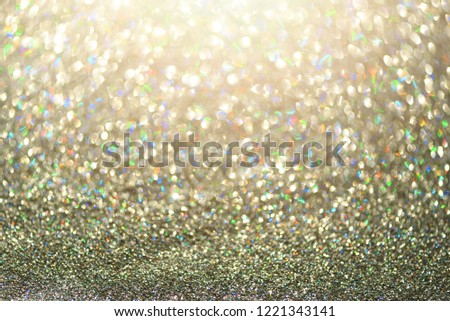 Colorful glitter background with lights, bokeh. Shiny festive greeting card. New year and Christmas concept. Sparkling texture.