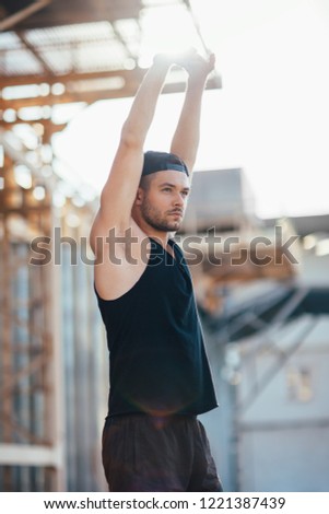 Young handsome man stretching outdoor. sportsman warming up before sports training