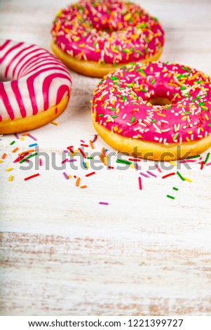 Pink donuts on a wooden background. Delicious dessert.