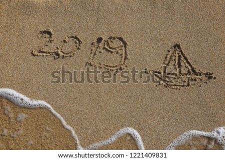Summer vacation concept. Summer 2019 written on wet sand at the beach
