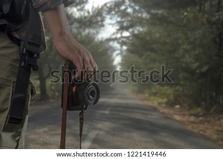 Close-up shot of man holding camera standing on the road