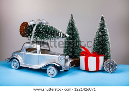 Silver retro car with a tree on the roof. Christmas decor. Car model.