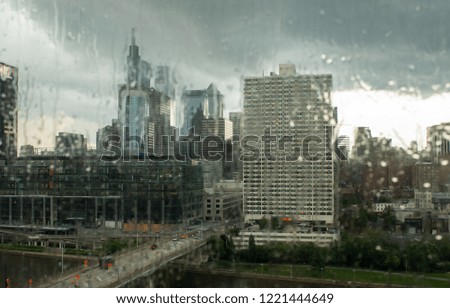 Looking at a city through the rain streaked glass of a building.