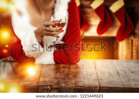 Table background of free space for your decoration and santa claus woman with glass of wine. 
