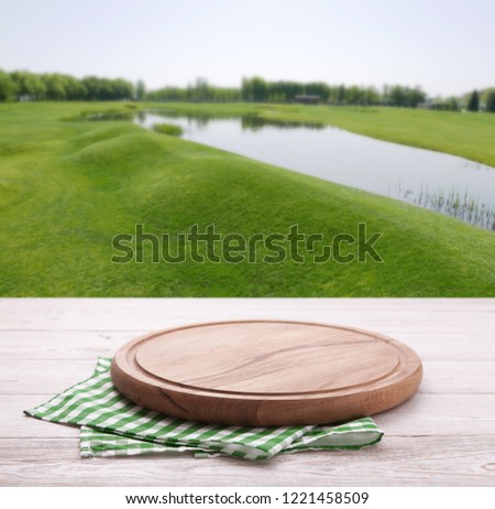 Pizza board, with tablecloth on wooden table and summer sea background. Top view mockup