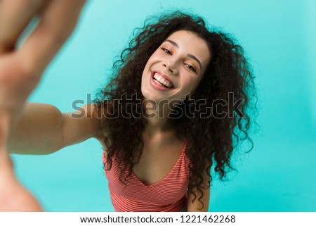 Image of gorgeous woman 20s wearing casual clothing laughing while taking selfie photo standing isolated over blue background
