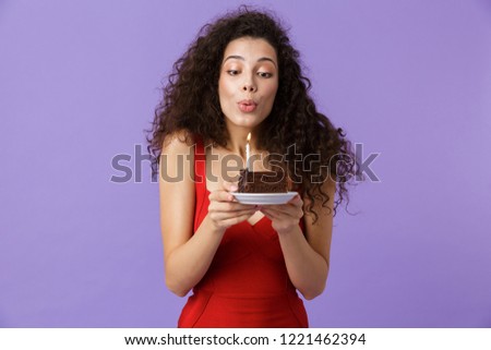 Image of joyful woman 20s wearing red dress holding piece of bir