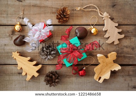 Topview green and red gift boxes with pinecone and christmas tree and angle which make from wood decorate for christmas theme 