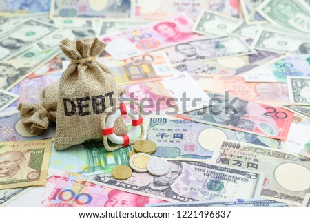 Credit default insurance  debt security concept : Debt bags, red lifebuoy on world banknotes e.g dollar, yuan, depicts a financial agreement that mitigates the risk of loss from default by a borrower Royalty-Free Stock Photo #1221496837