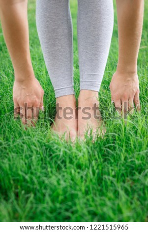 Legs of a young girl on the grass do yoga and their health