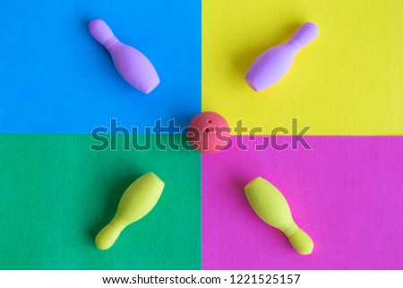 Flat lay of rubber ball with bowling pins toy on colorful background minimal creative concept.