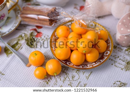 Decorative orange mandarins, tangerines, cup of tea, home mandarins, small mandarines, front view